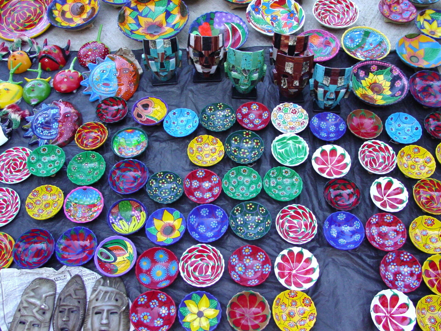 Colorful handmade coasters and mugs displayed at a market stall.