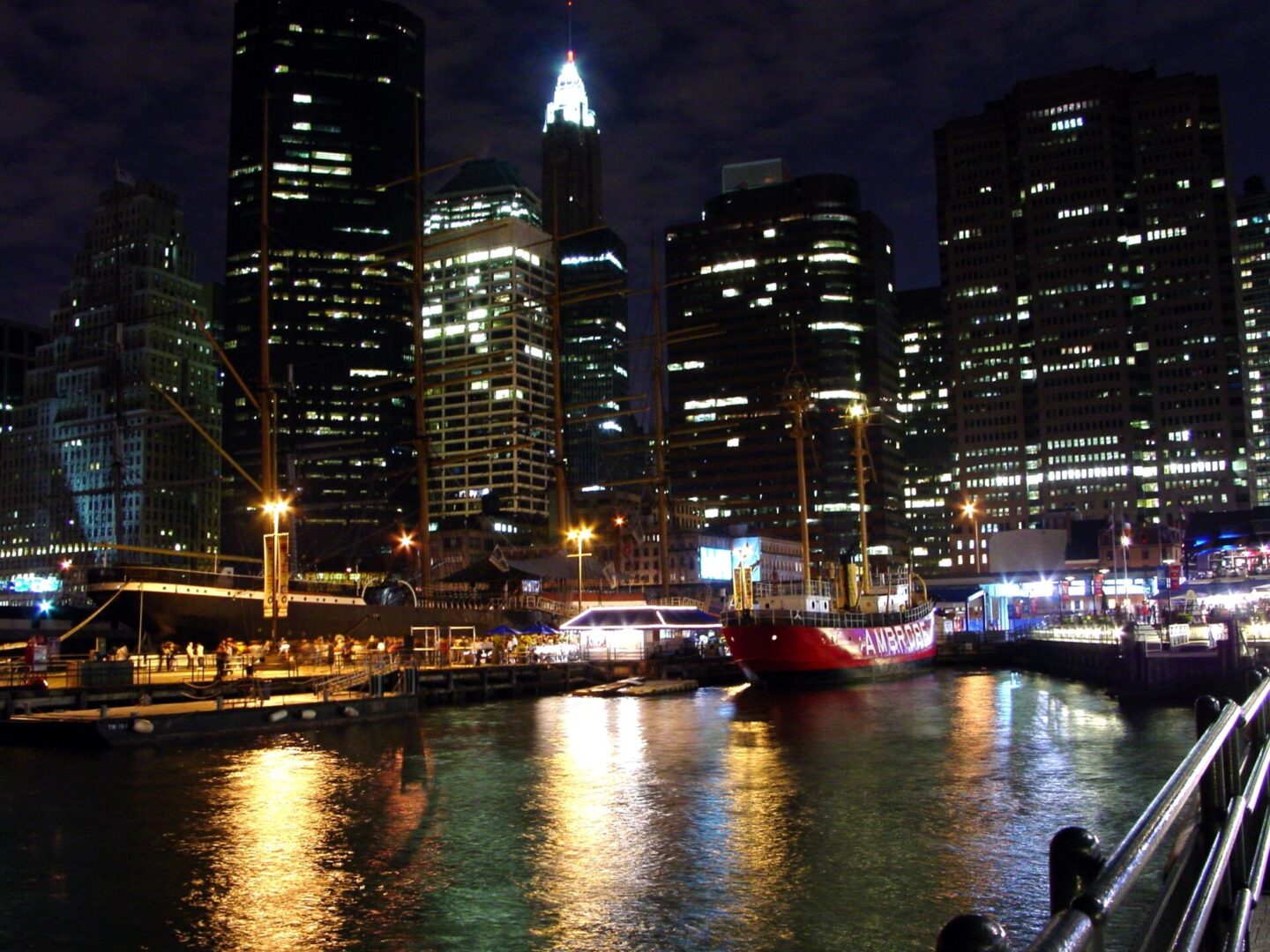 City skyline illuminated at night with reflections on the water.