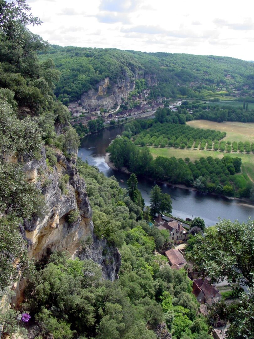 A winding river flows through a lush, rocky valley with green fields.