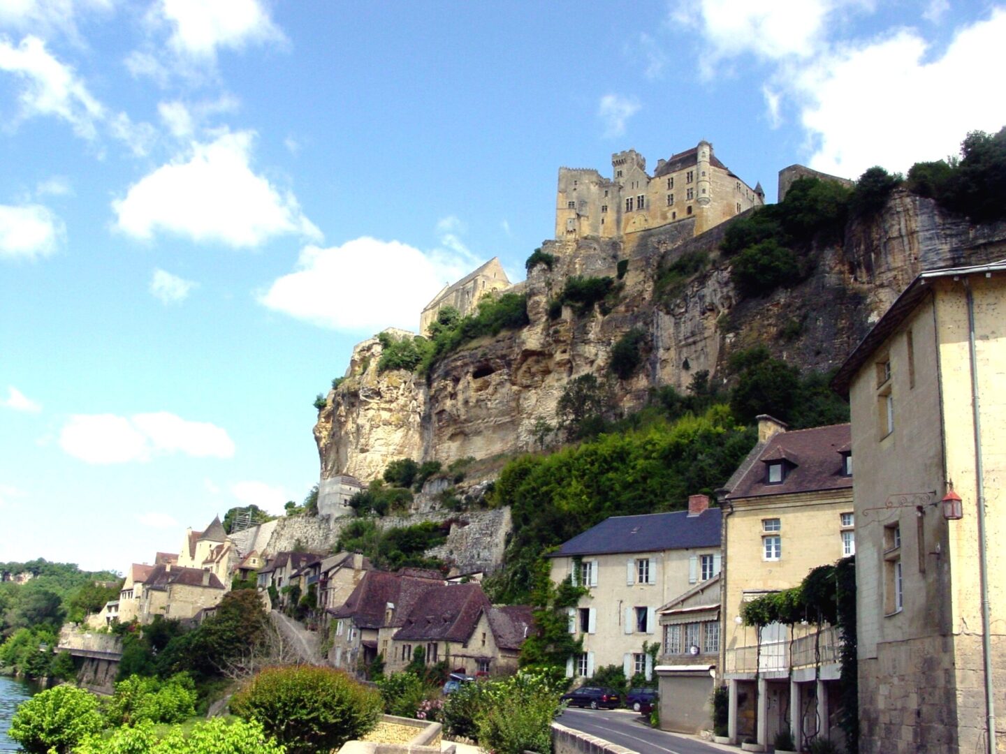 Historic castle perched atop a rocky hill overlooking a quaint village.