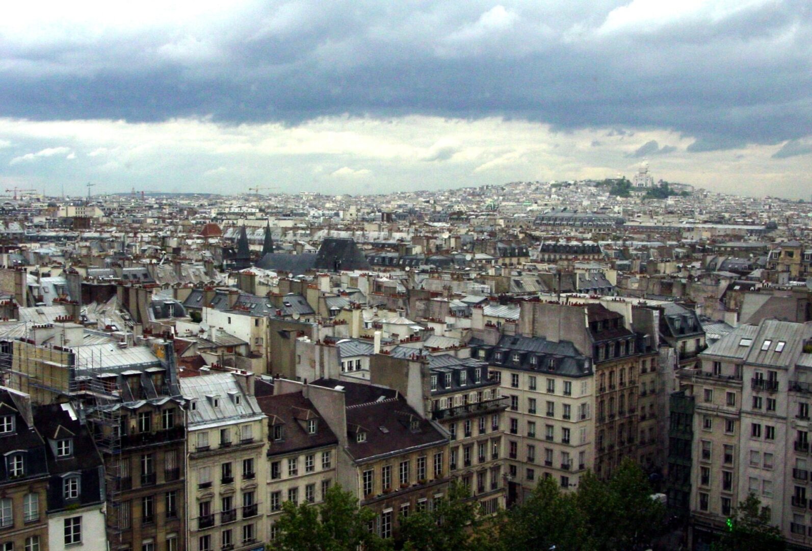 Cloudy sky over a sprawling cityscape with historic buildings.