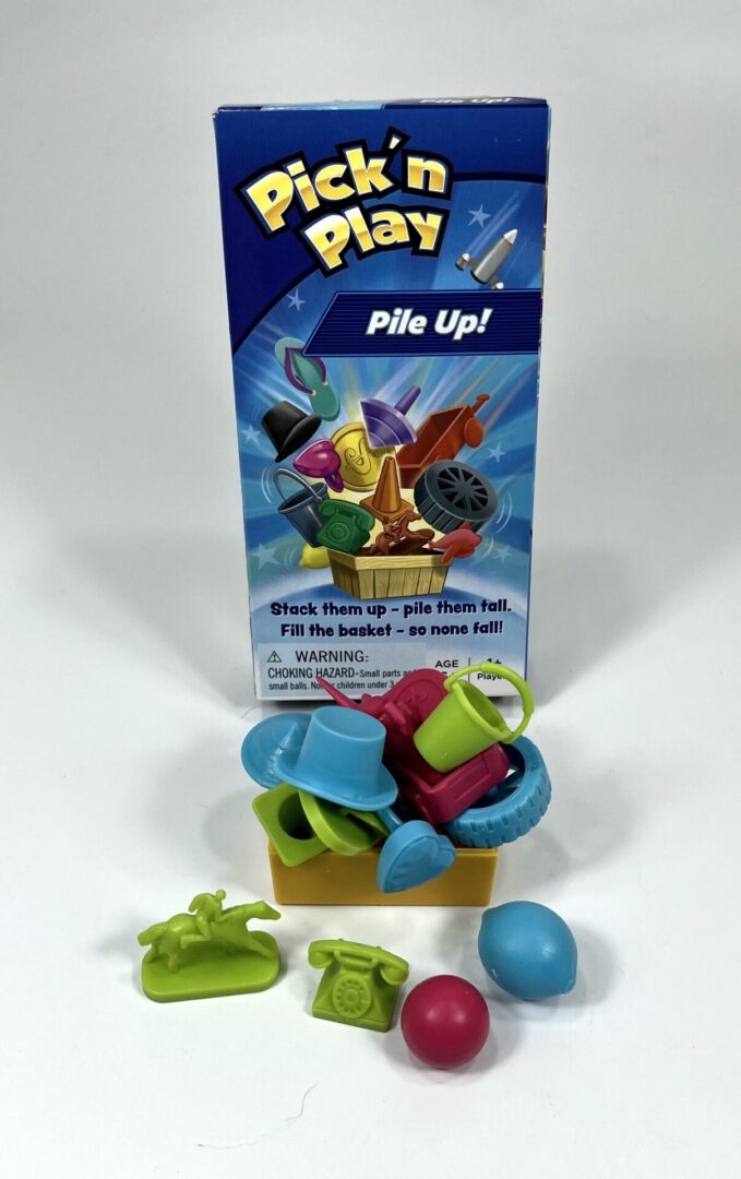 Colorful plastic pieces from a stacking game next to its box.
