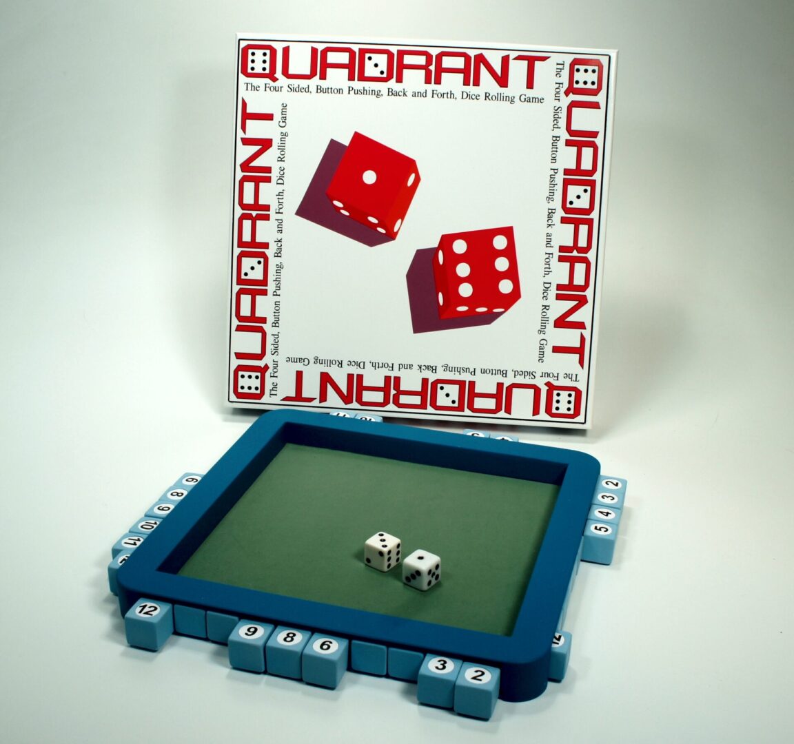 A dice game set with red dice, a blue tray, and a box labeled Quadrant.