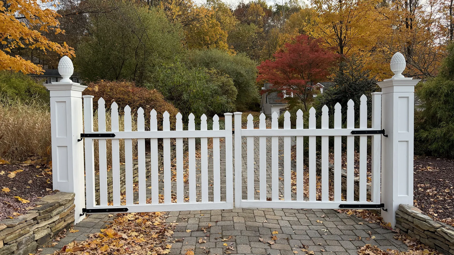 White wooden garden gate with autumn foliage background.