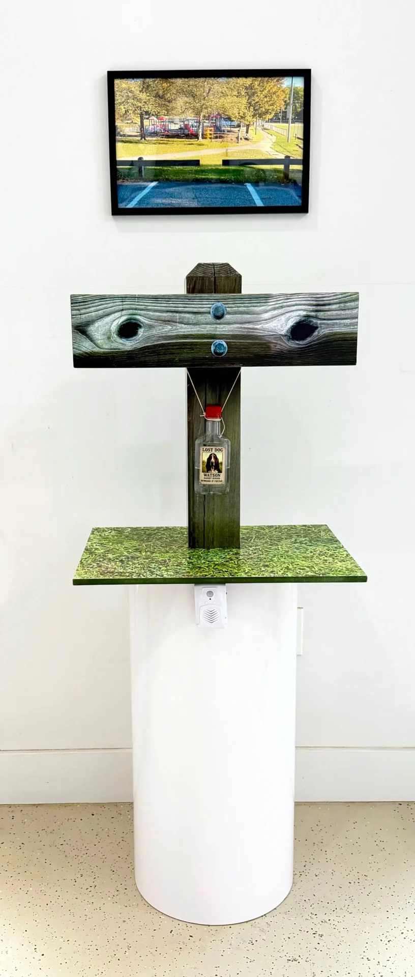 Modern abstract sculpture with geometric shapes and a small figurine.