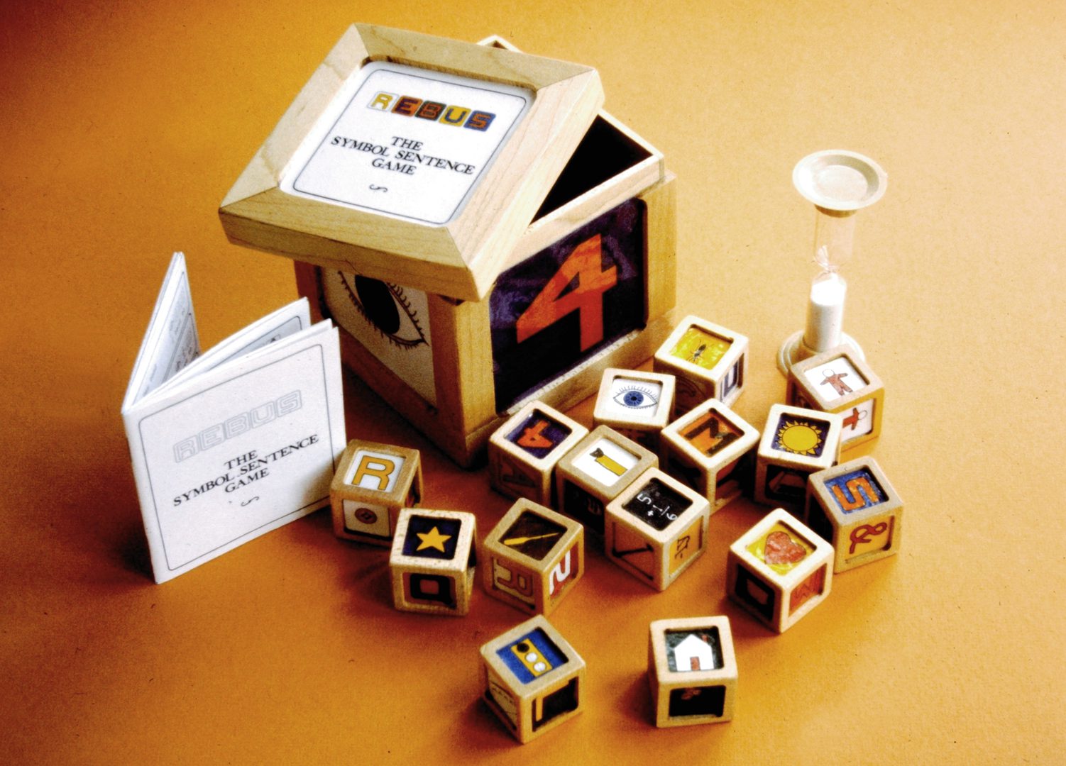 Wooden alphabet blocks spilling from a toy house.