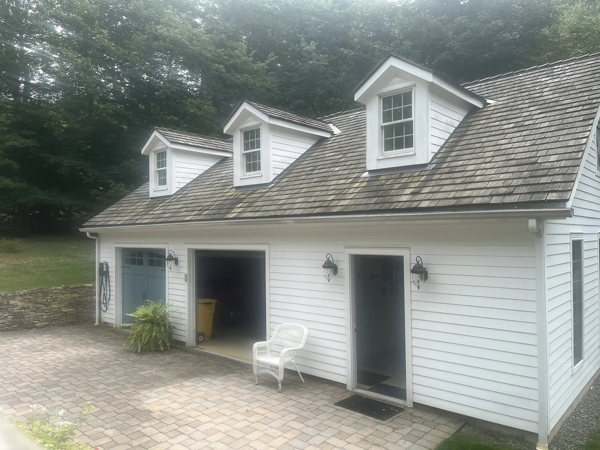 White cottage with dormer windows and a shingled roof.