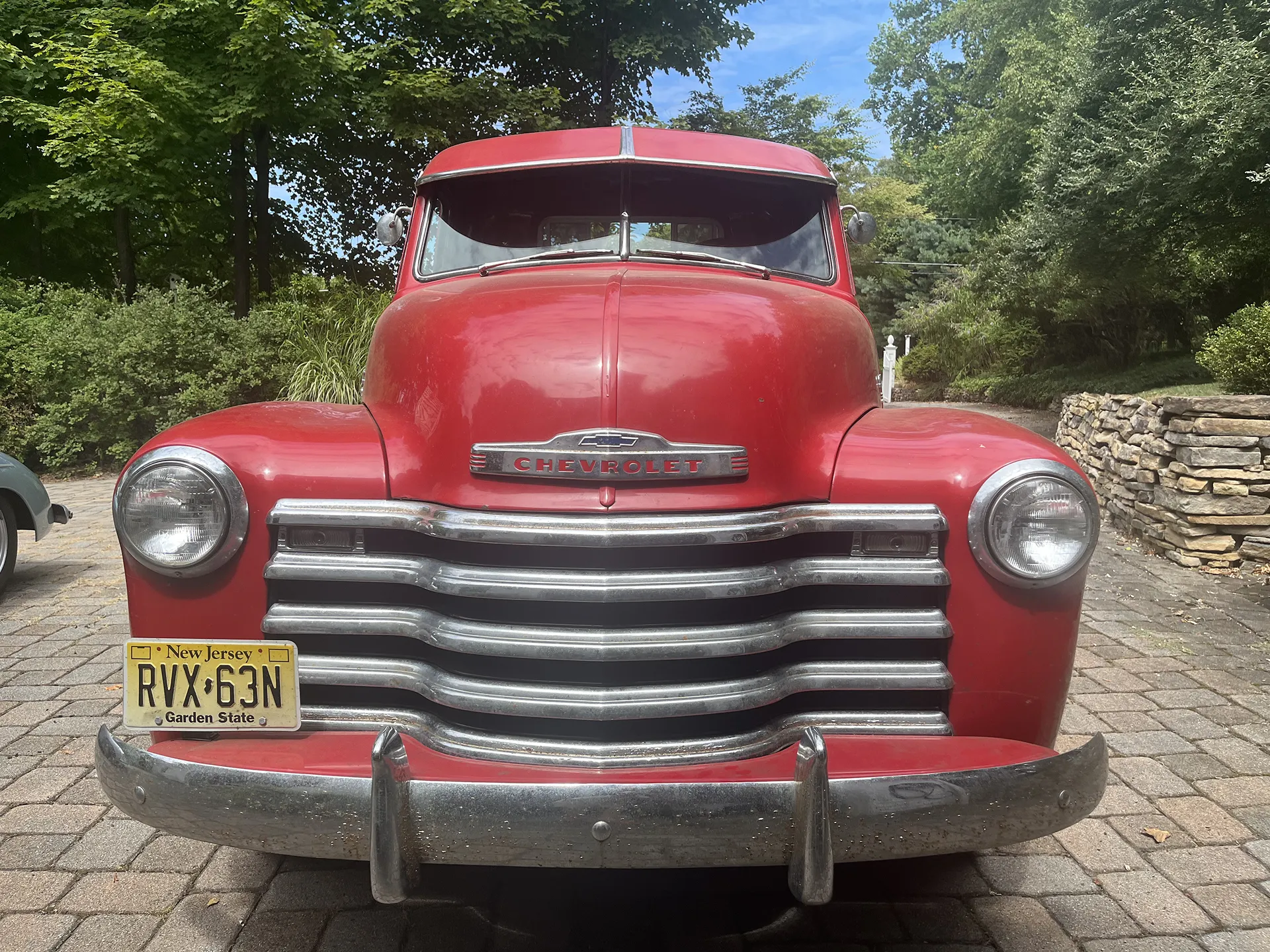 Front view of a classic red Chevrolet truck with chrome grille.
