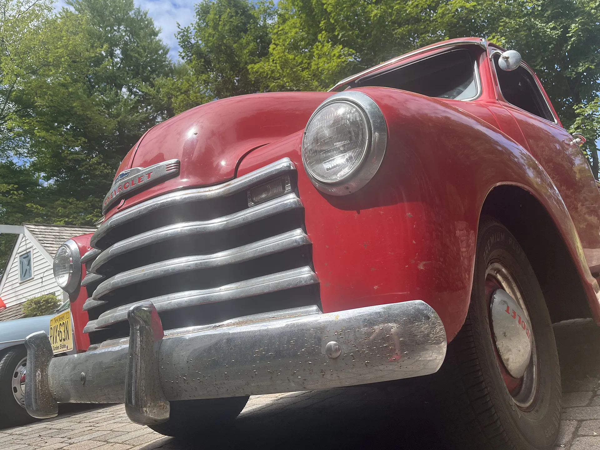 Front view of a vintage red Chevrolet car with chrome grille and bumper.