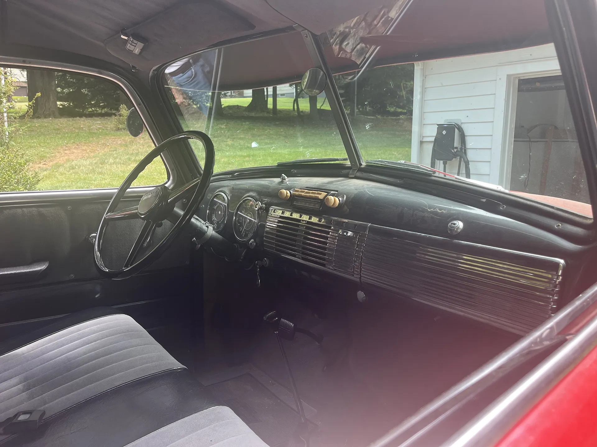 Interior view of a vintage car showing the dashboard and steering wheel.