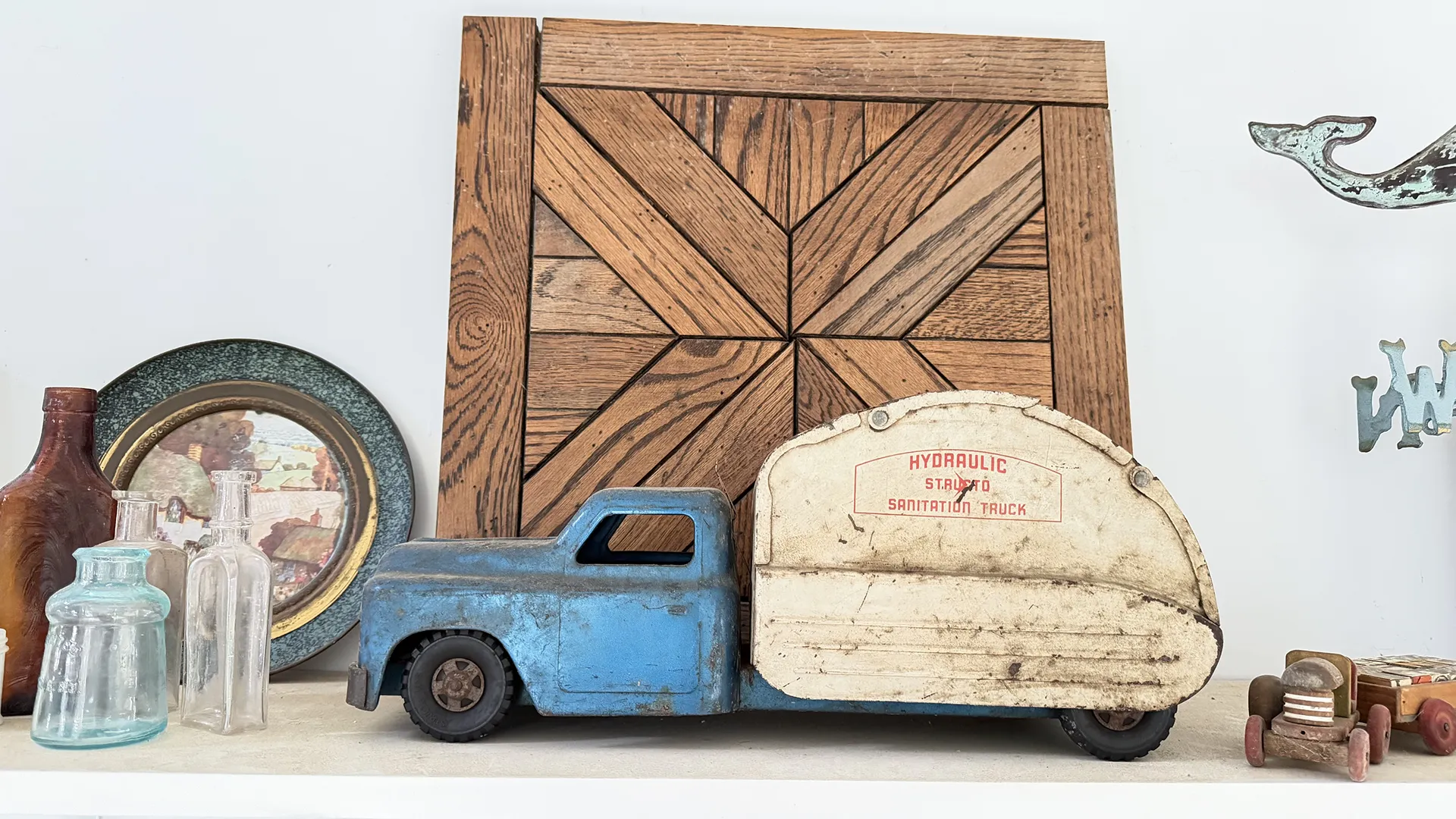 Vintage toy delivery truck with blue cab and white trailer.