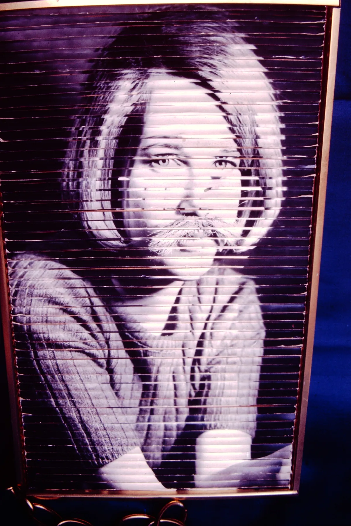 Black and white pixelated image of a woman with short hair, looking sideways.