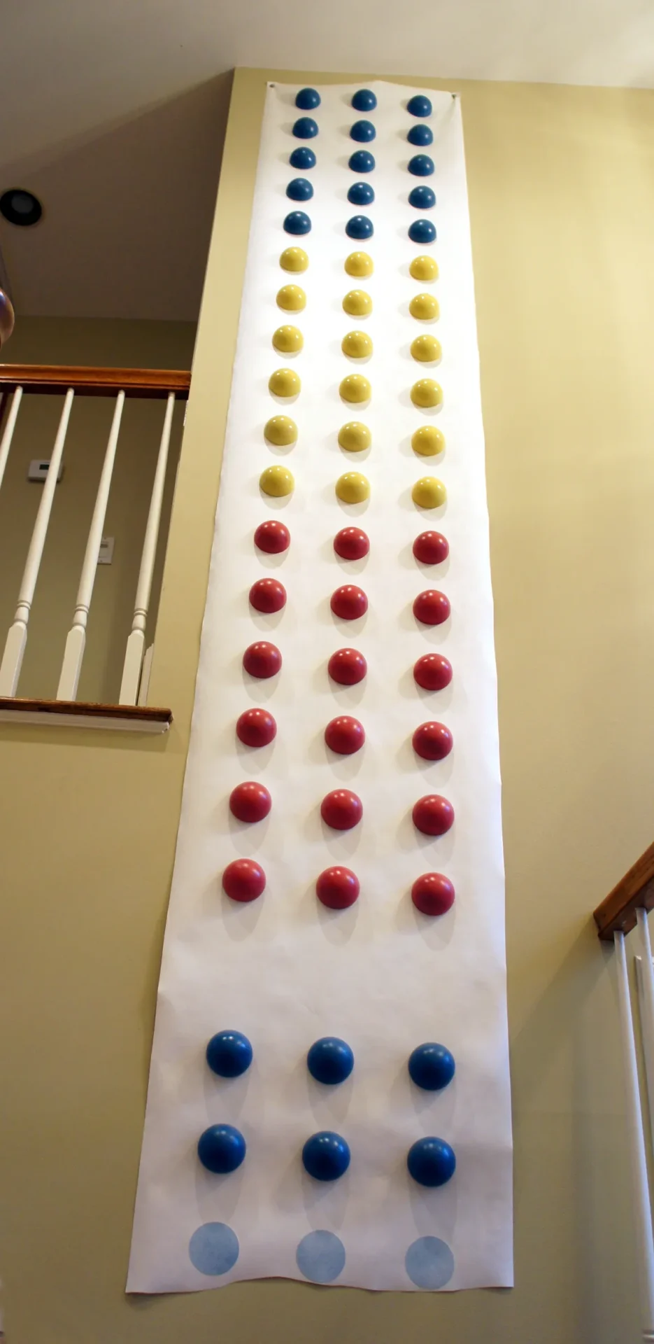 Wall-mounted colorful balls arranged in columns.