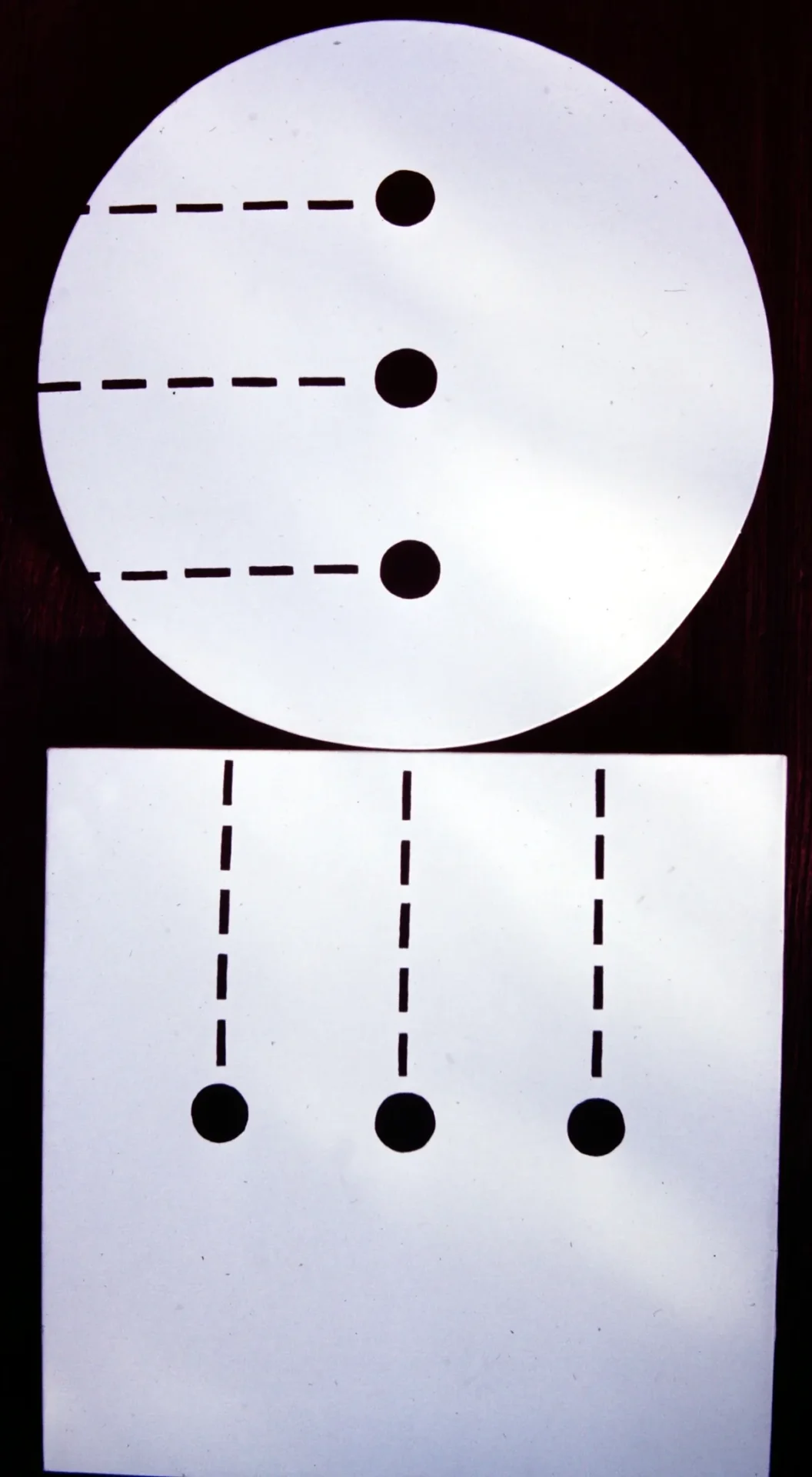 A visual puzzle with black dots and dashed lines on white circles and squares.