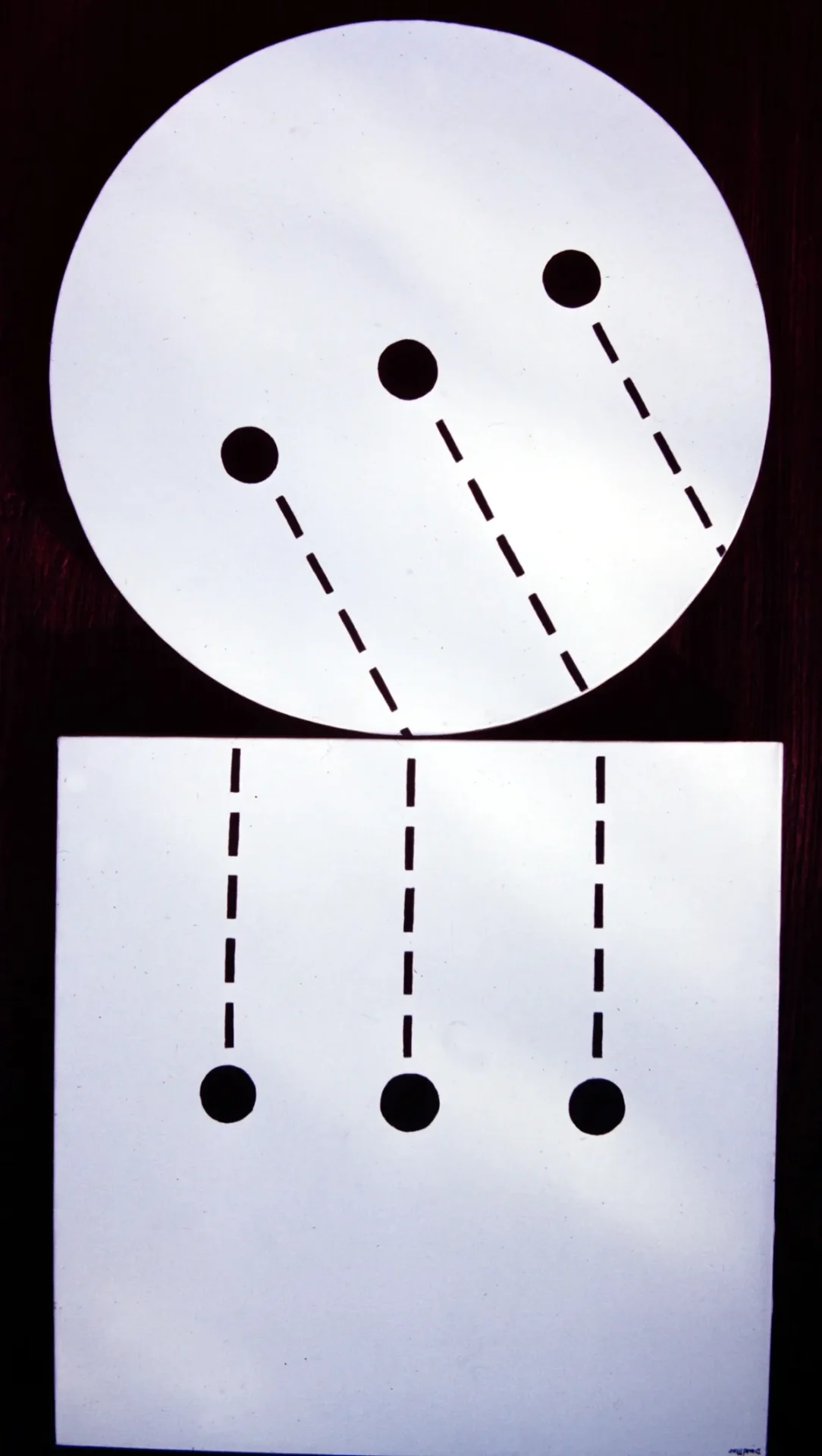 Two white sheets with black dots and dashed lines arranged vertically.