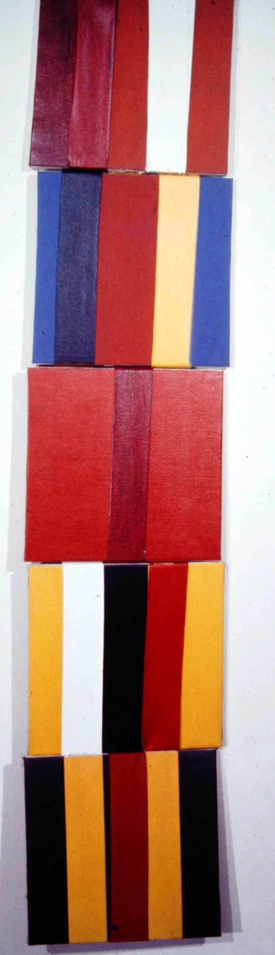 Stack of colorful books arranged with red books in the center.