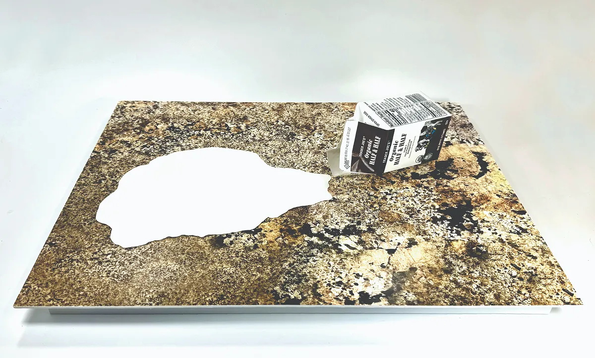 Spilled milk carton with milk pooling on a countertop.
