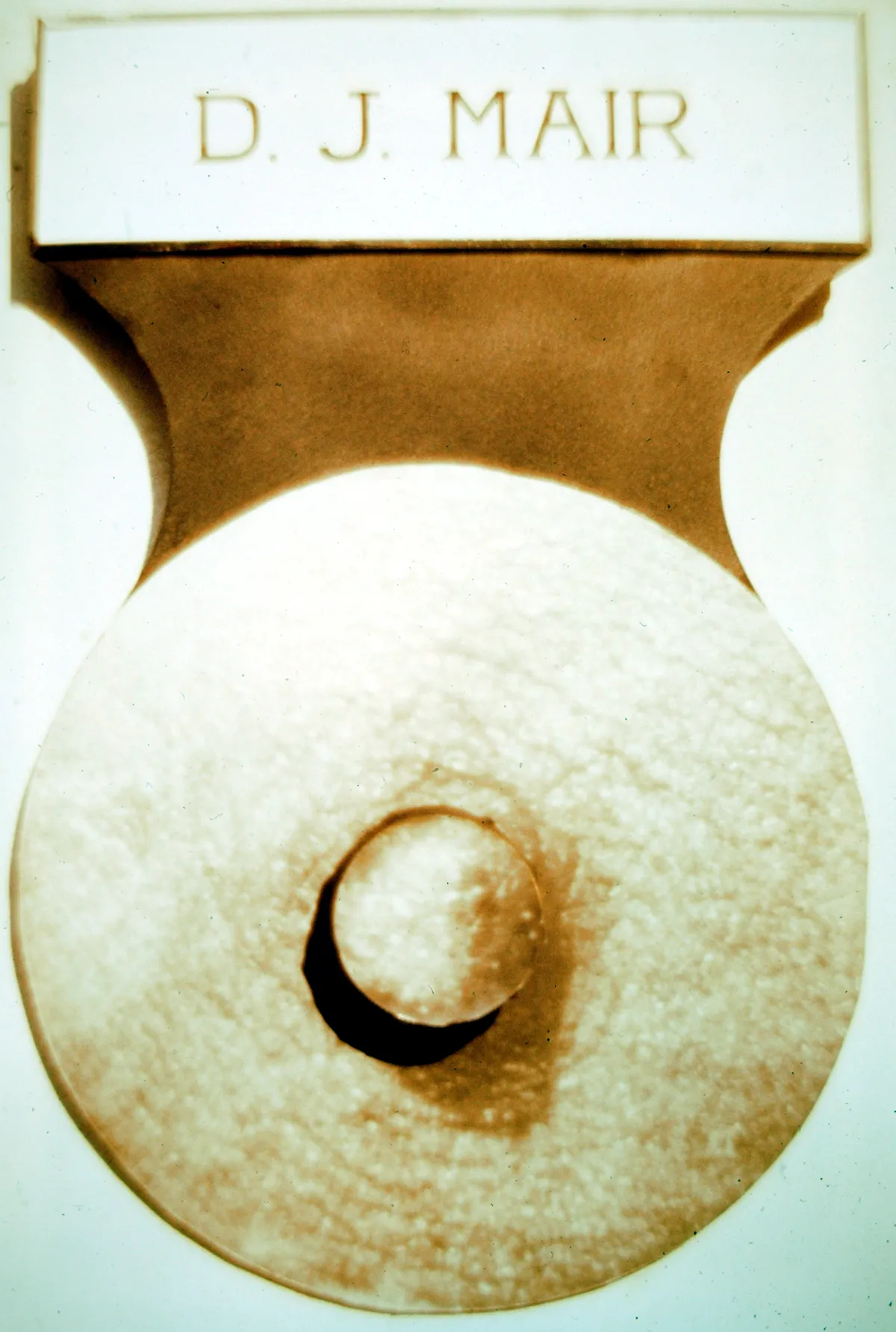Ancient stone grinding tool with wooden handle.