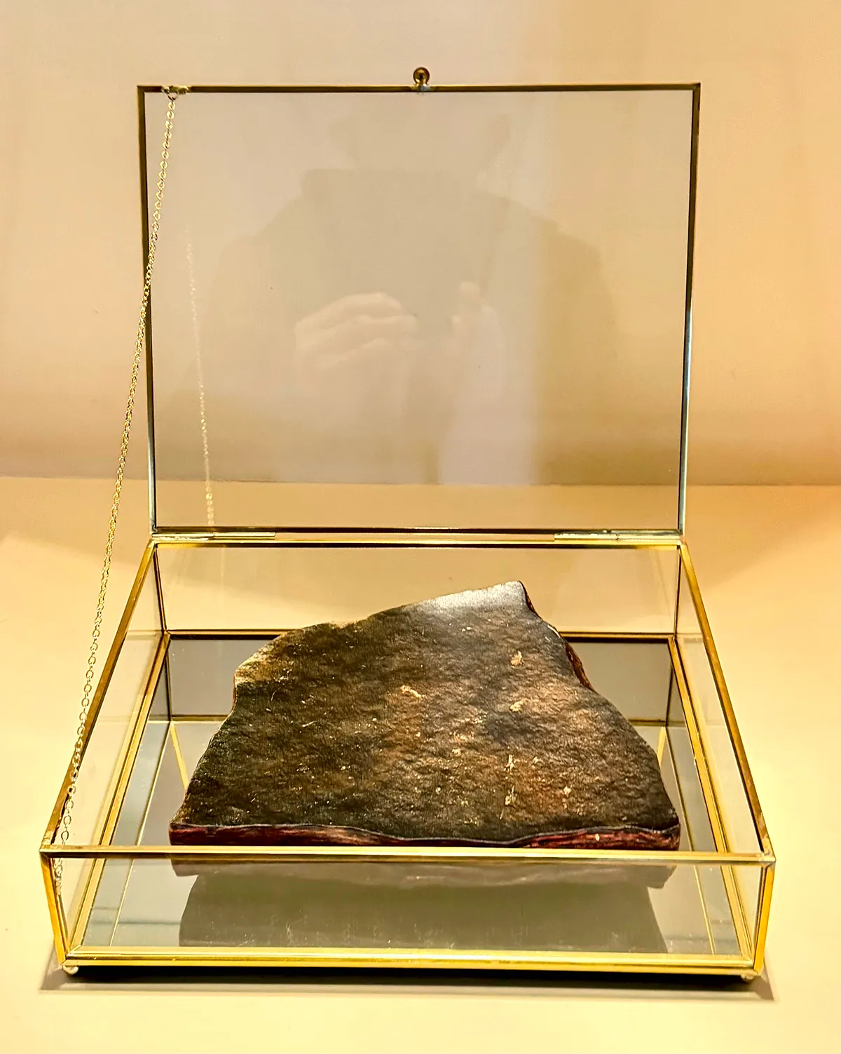 A preserved meteorite displayed in a glass case.
