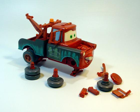 A toy truck with detachable parts scattered around it.