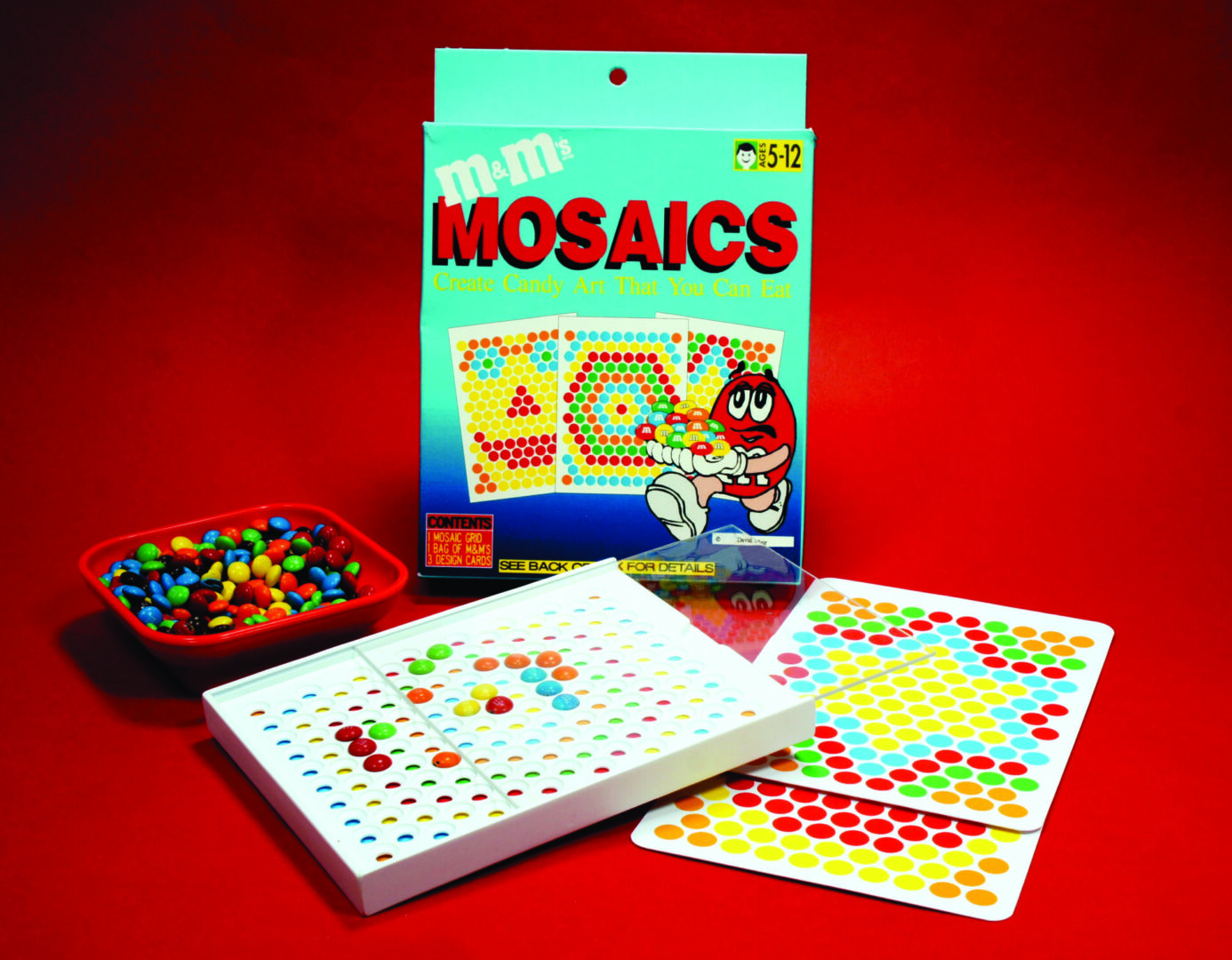 Colorful vintage Milton Bradley mosaics toy with pegboards and pattern cards.