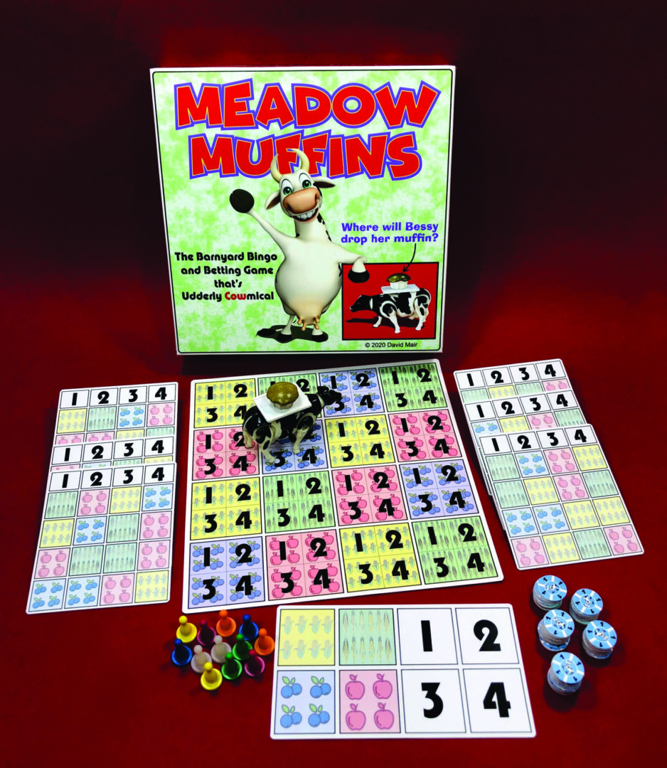 A Meadow Muffins bingo game setup with cards, markers, and dice.