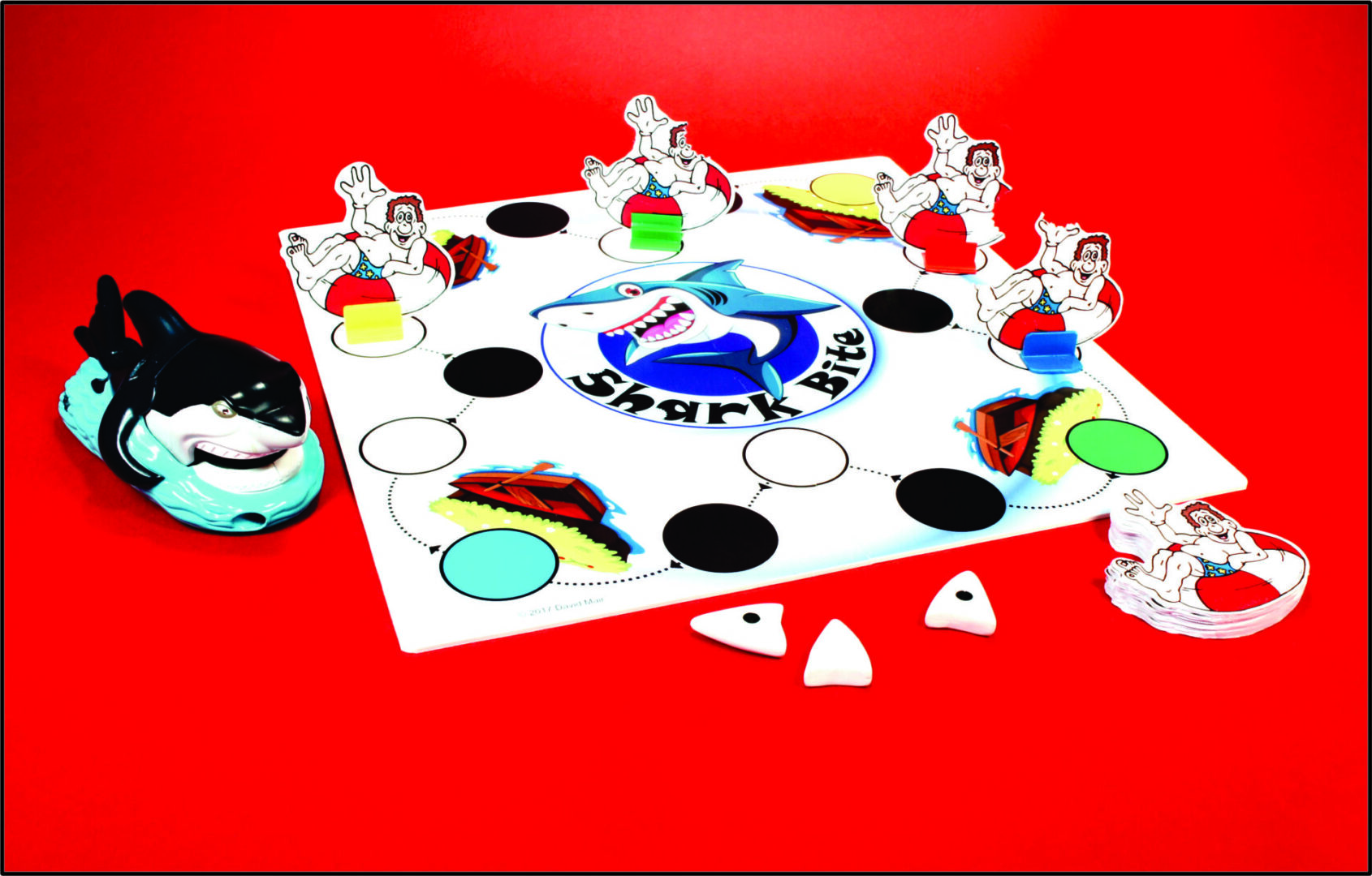 A colorful board game with tokens and dice on a red surface.