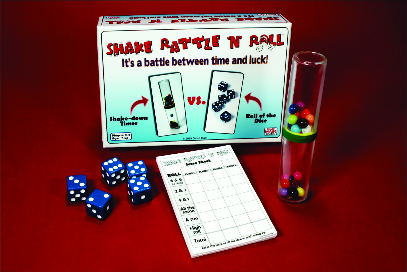 Board game setup with cards, dice, score sheet, and timer on red surface.