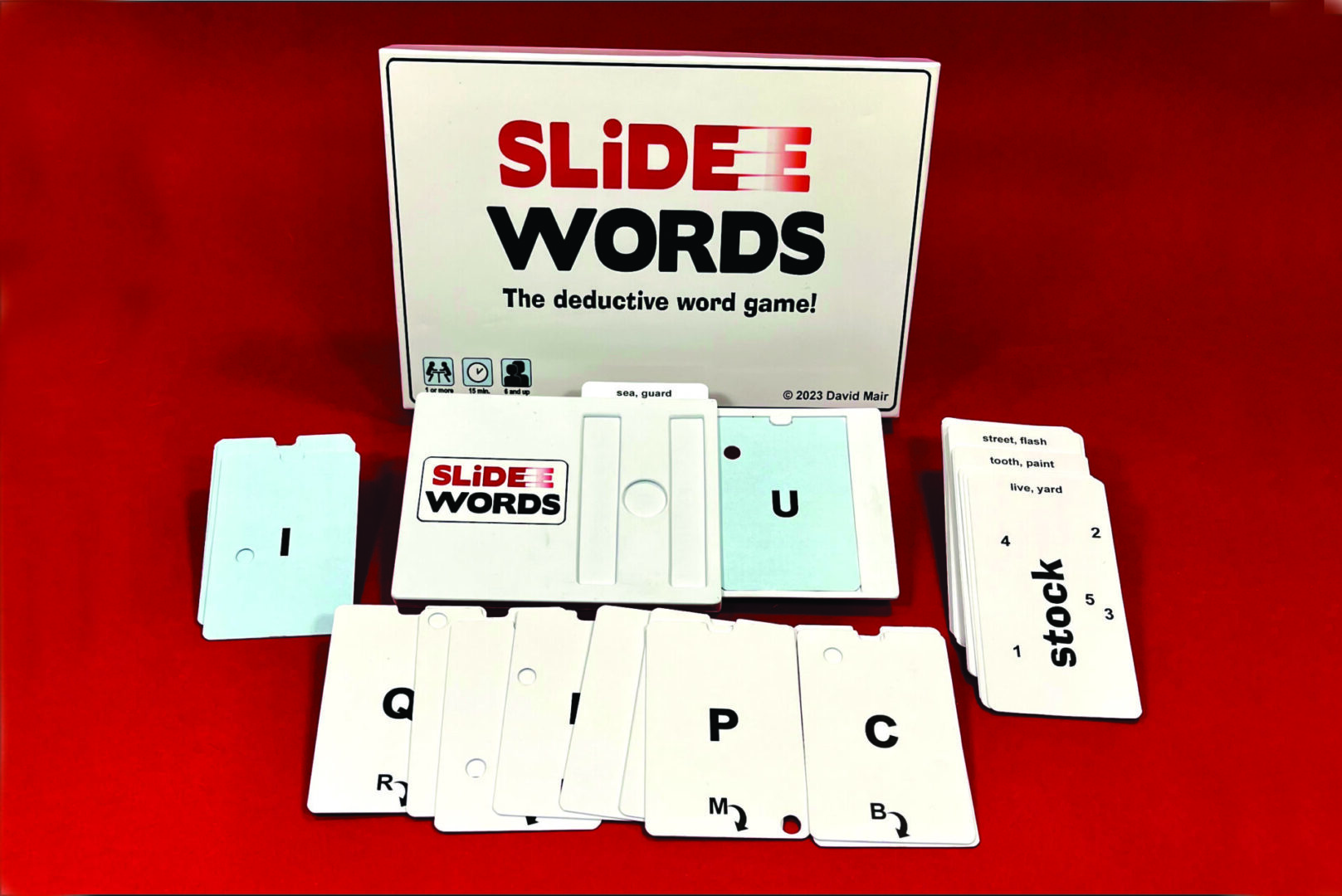 A Slide Words deduction card game with letter cards and game box.