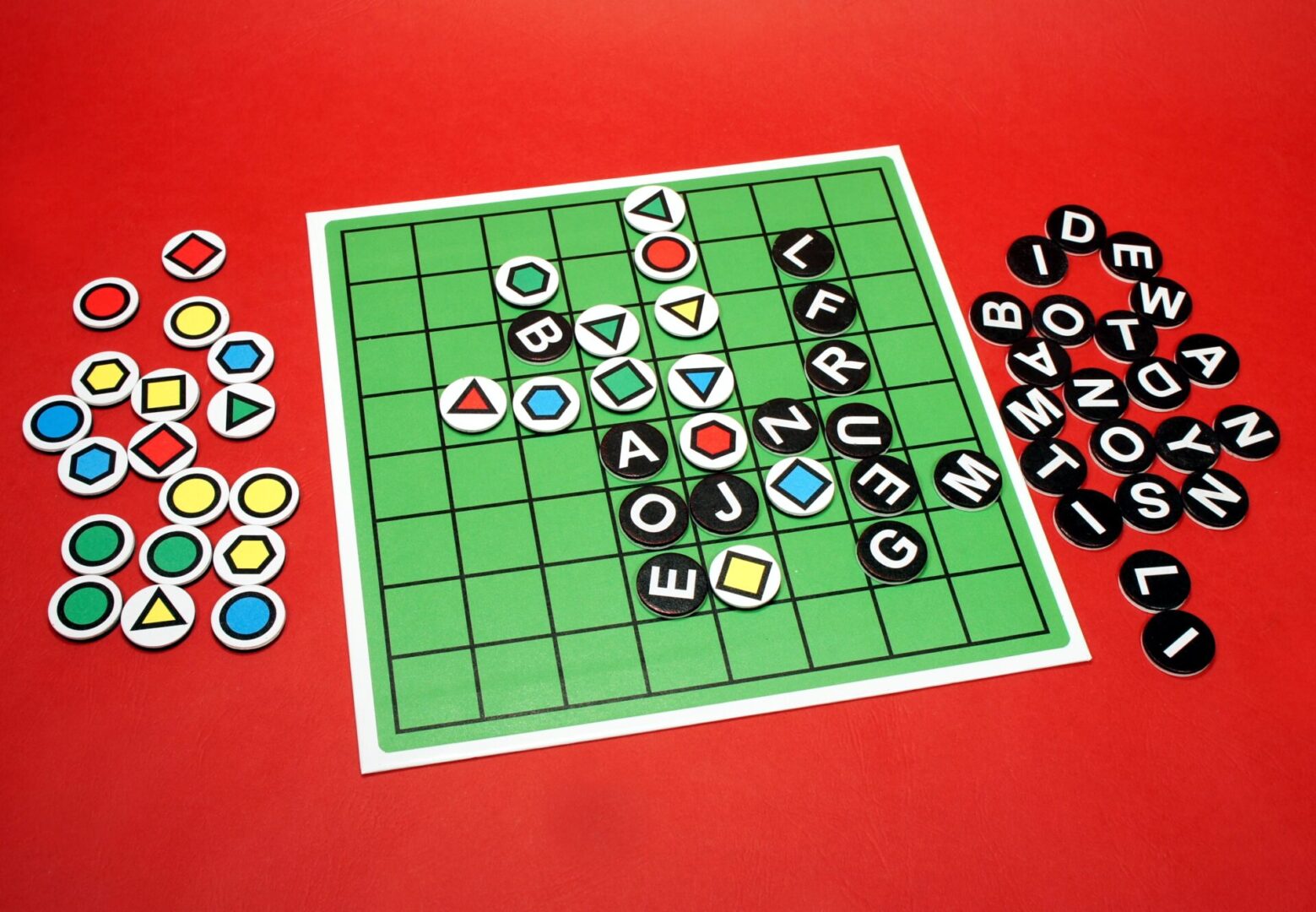 A word-building board game in progress on a red table.
