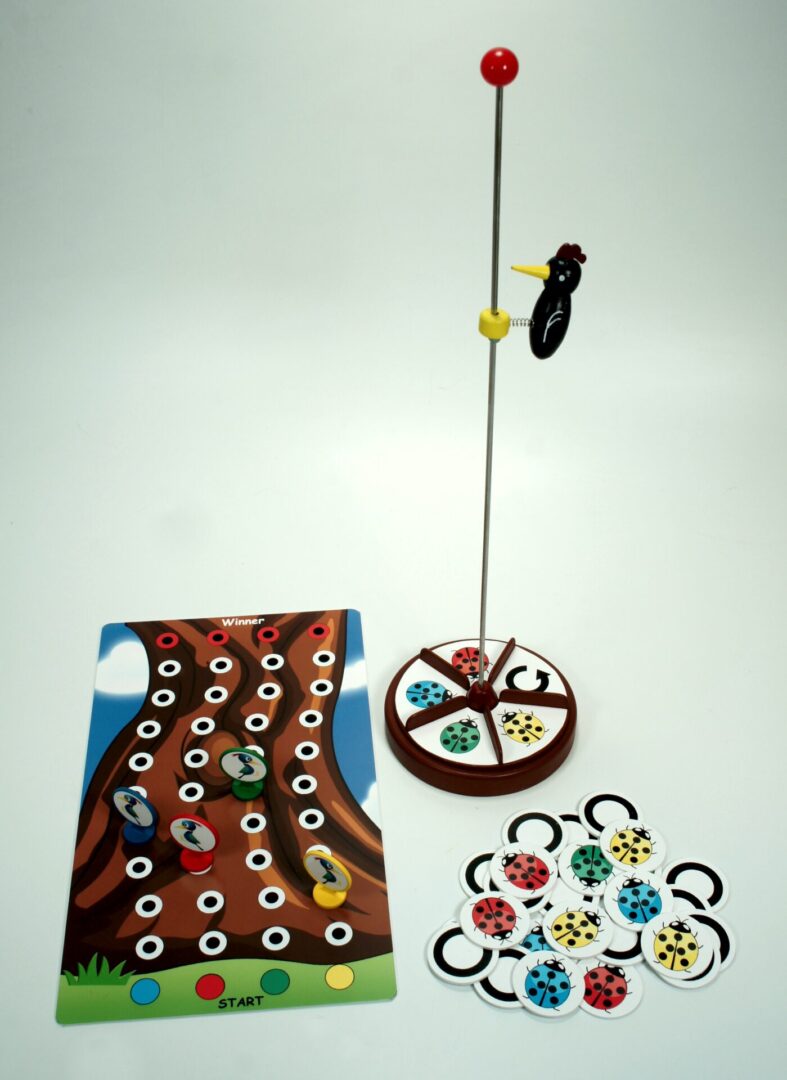 A colorful board game setup with cards and spinner on a white background.