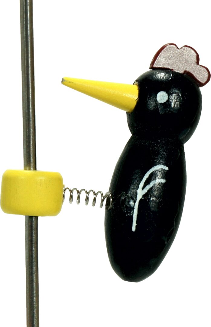 A quirky black bird figurine with a yellow beak and spring stand.